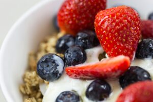 Close-up of fresh blueberries and strawberries on yogurt with granola.